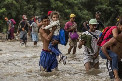  Famílias venezuelanas cruzam o rio Tachira em busca de comida e segurança em Cúcuta, na Colômbia.
